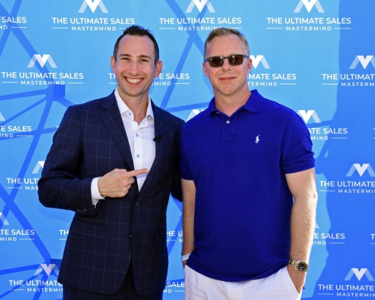 Brandon Bornancin and Michael Hopkins standing in front of an event backdrop.